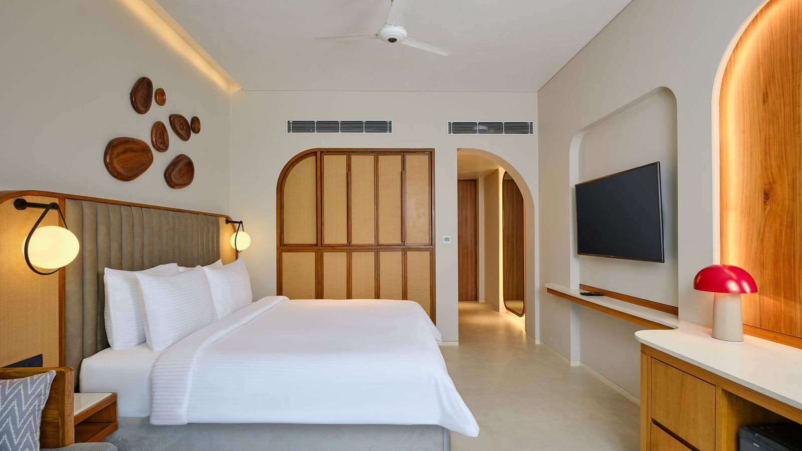 Image of Premium Room at Swosti Premium Beach Resort in Puri featuring a plush bed and a TV mounted on the wall along with a wardrobe next to the bed