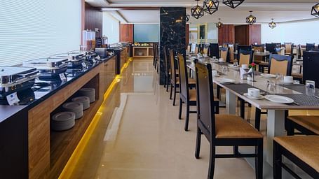 Table arrangement besides the buffet set up at Blue Salt and Coffee at Essentia Premier Hotel, Chennai