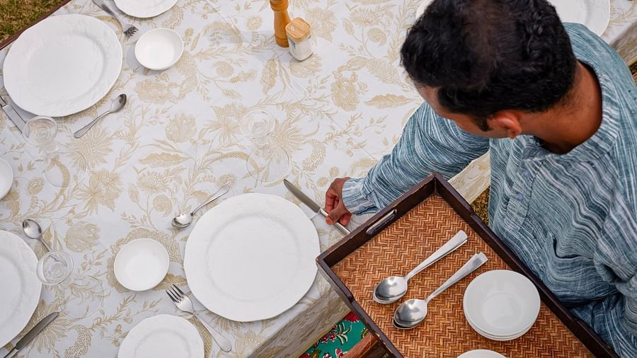 image of a person setting up the dining table with cutlery at dev shree, deogarh