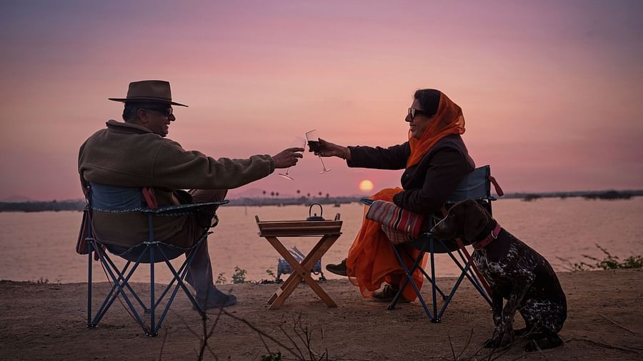 image of a couple enjoying the sunset as they cling wine glasses at Dev Shree, Deogarh