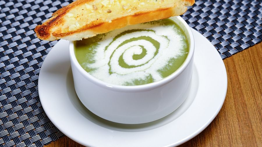 A bowl of soup served alongside a piece of toast - Essentia Premier Hotel, Chennai