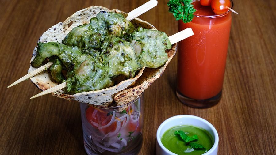 A starter served with mint chutney and a glass of strawberry juice