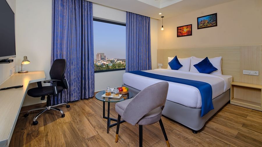 A room at Essentia Premier Hotel, Chennai with a double bed, a television and a work desk and chair
