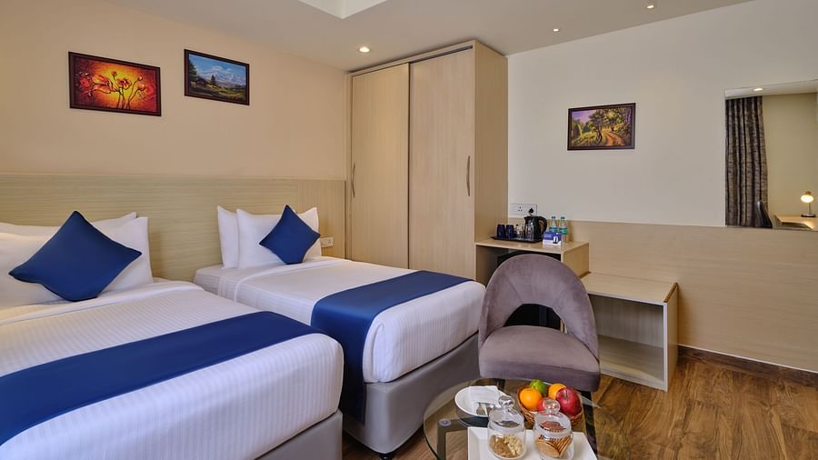 A room at Essentia Premier Hotel, Chennai with twin beds, a wardrobe and a coffee table
