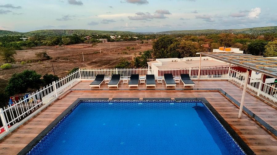 View of the swimming pool with lounge chairs on the side  at Vagator Downtown, Goa
