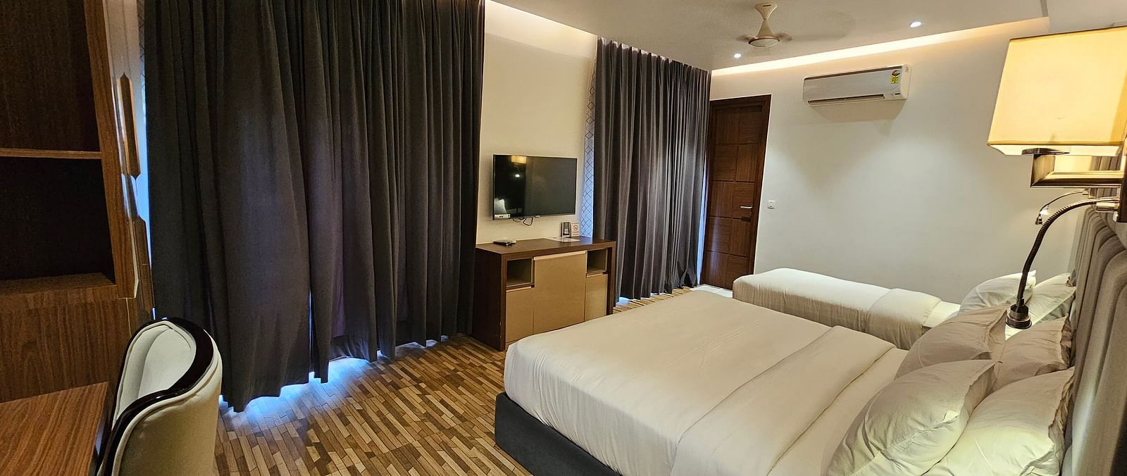 a family executive room at Eminence The Corbett with curtains drawn over the windows