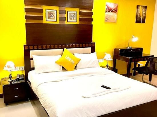 An image of a bedroom with king size bed, a bedside table with lamp and a seating area with table and chairs - Lime Tree, Greater Kailash - 2