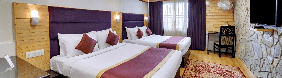 An image of a room with twin bed, flat screen TV, decorative lighting - Sumitel Darjeeling