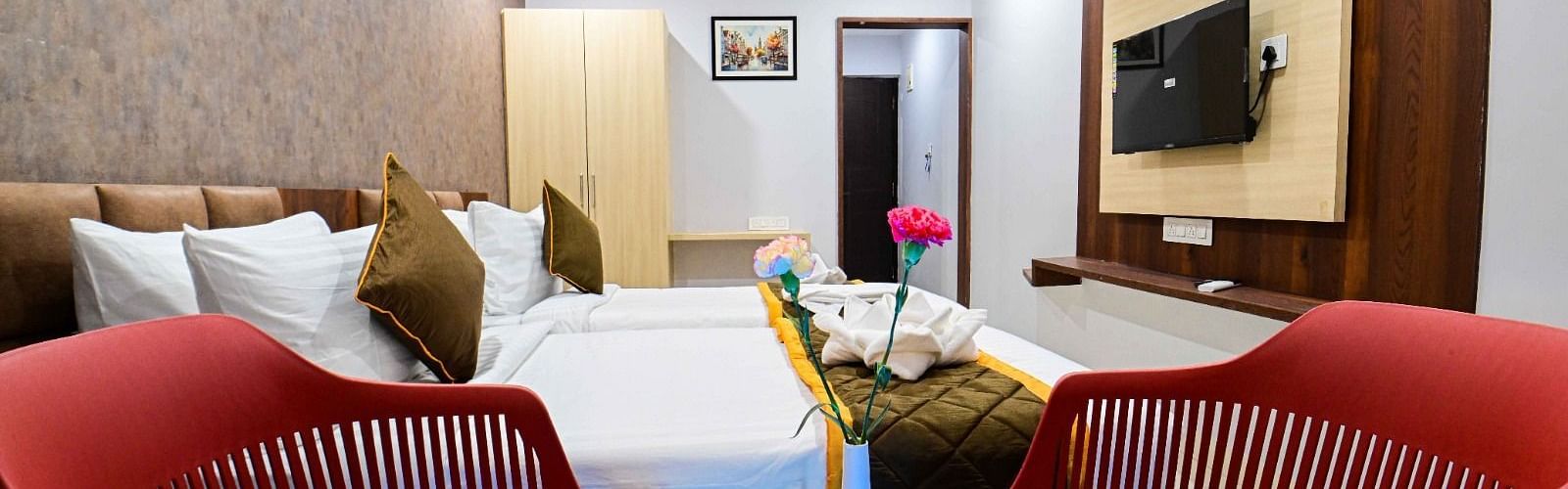 view of the  comfortable sofa setting and TV  and king size bed of Premium Balcony Room at at South Square Hotel, Bengaluru