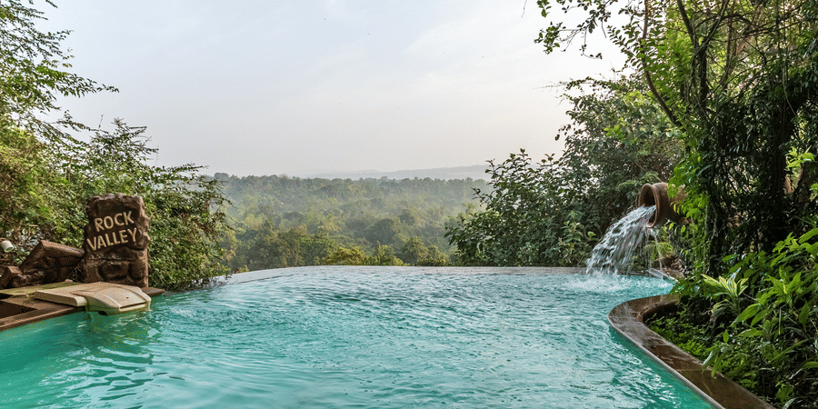 An infinity pool looking out over a wide green landscape.
