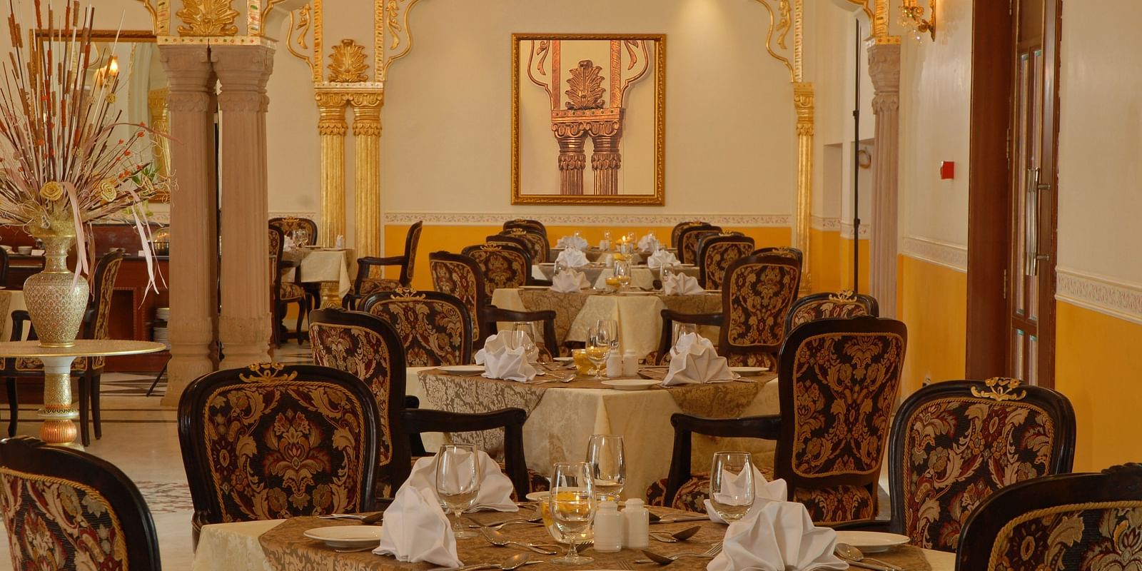 A dining space with seating area a photo frame on the wall at Rajasthali Resort & Spa Jaipur.
