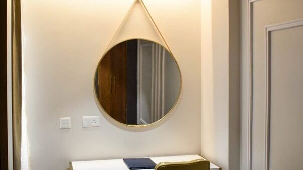 Study table with a mirror hung on the wall in teh suite at Tulip Inn, Shravasti