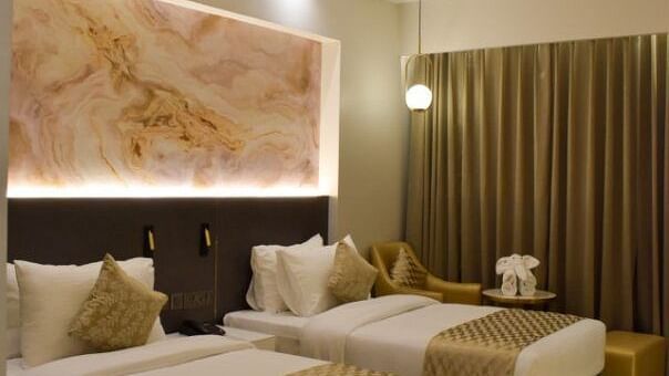 Twin beds with bed runners on it inside executive room at Tulip Inn, Shravasti