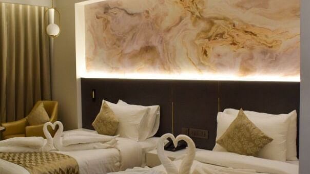 Twin beds with dove shaped towels on it inside executive room at Tulip Inn, Shravasti