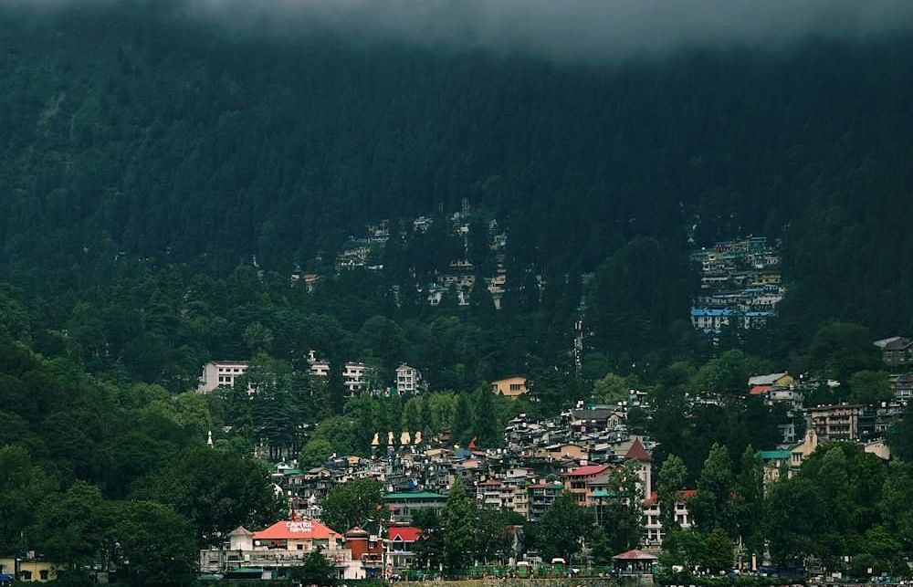 Tranquil lake surrounded by rolling hills dotted with charming houses.