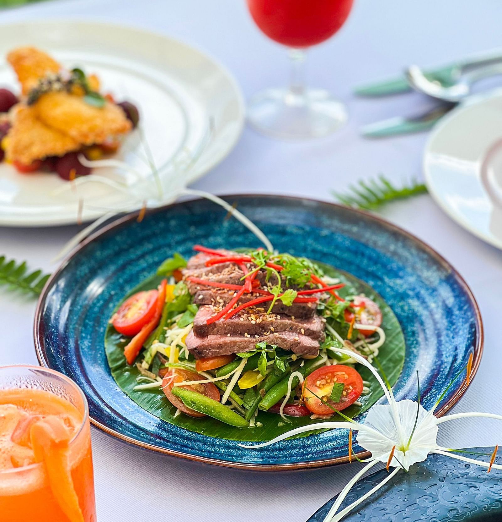 An image of a served meat dressed along with other vegetables - Alibu Resort Nha Thrang