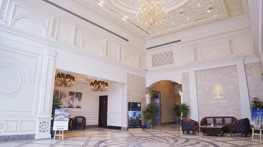 Seating arrangements inside the lobby with a chandelier above - Rhythm Gurugram