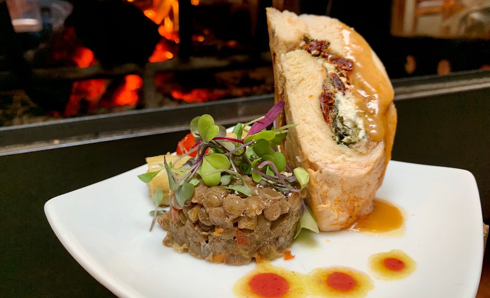 A stuffed pastry dish plated with colorful sauces - Brewery Gulch Inn & Spa