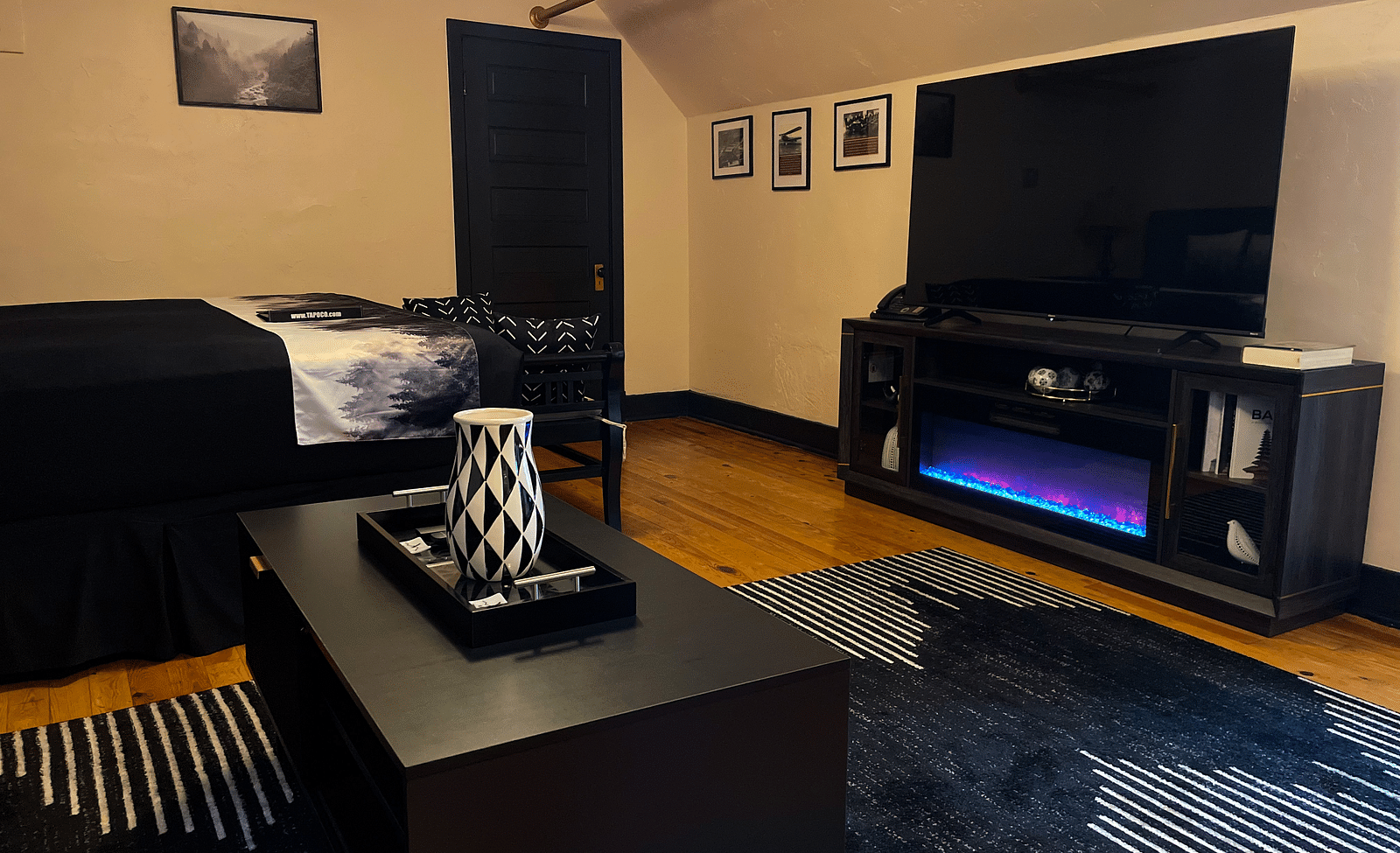 a common seating area featuring a wide flat screen television complimented by a sound system - Historic Tapoco Lodge
