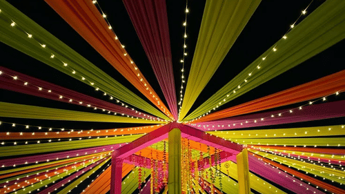 Hands holding dandiya sticks, ready to play during the traditional dance.