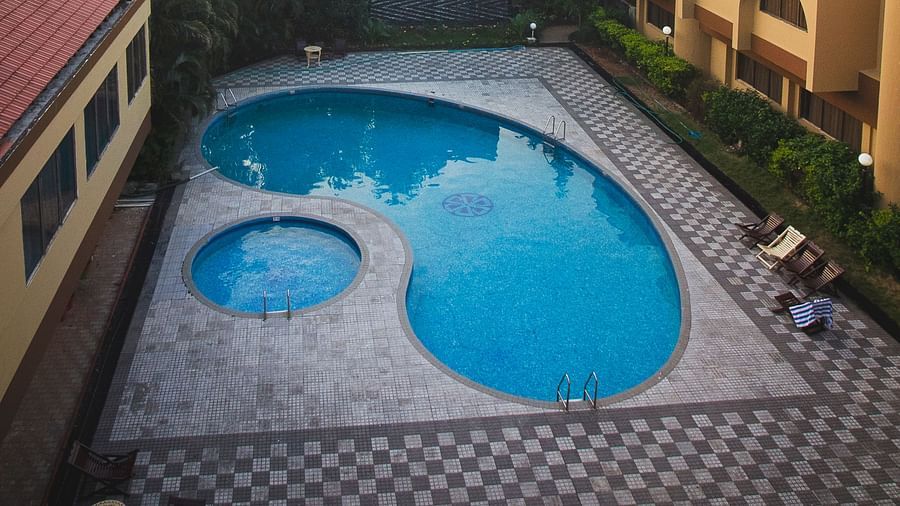 Aerial view of the swimming pools at Paradise Isle Beach Resort, Udupi with the resort in the backdrop