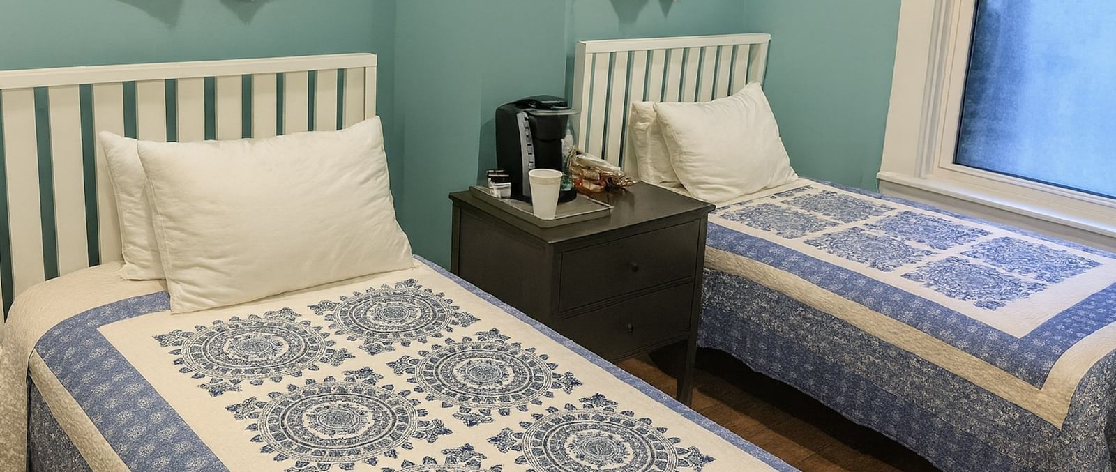 Deluxe Twin room at The Groverland Hotel, furnished with twin beds, a bedside table, and wooden flooring.