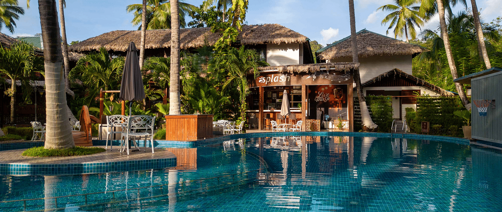  A panoramic view of a resorts outdoor pool area with tropical palm trees and well-maintained gardens surrounding the space. The setting creates a peaceful, relaxing environment - Coral Reef Resort & Spa, Havelock