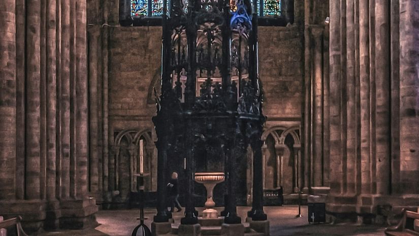 Interior view of a cathedral with the altar and a stained window behind it in view