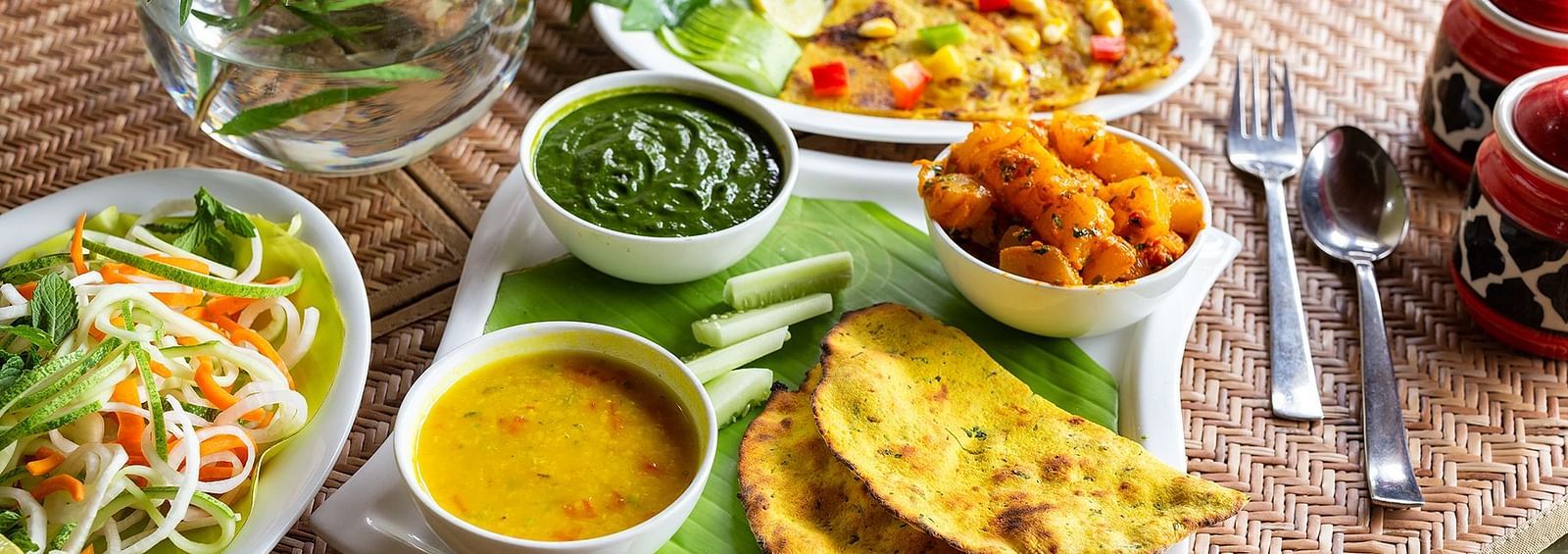Missi roti, palak curry, dal, and jeera pumpkin arranged on a platter.