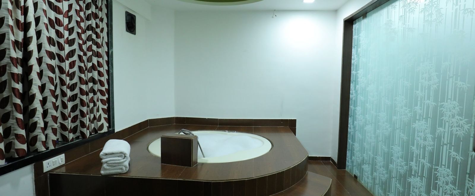 A washroom in Krushnai Resort room featuring a large, built-in Jacuzzi tub with steps.