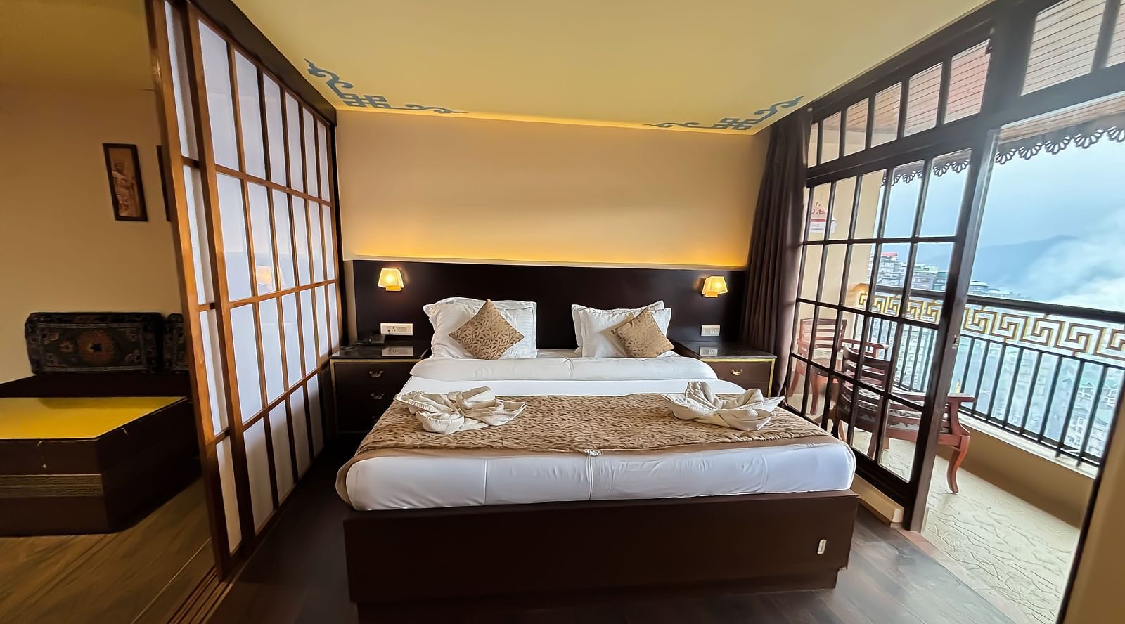 Bedroom with a balcony offering mountain views at Avianna Hungry Jack, Gangtok.