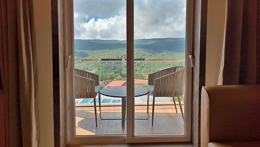 Room with glass doors opening to a private balcony with a scenic outdoor view
