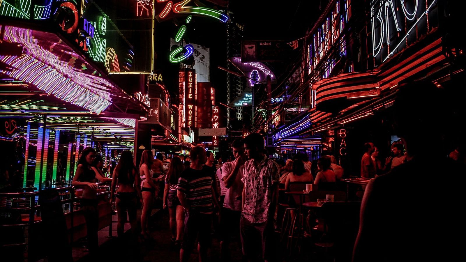 people walking on a street with led lights on buildings