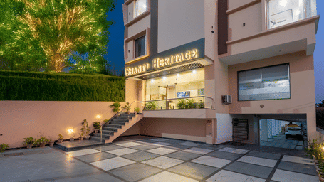 The hotel building entrance and paved driveway at late evening showing trees at Perfectstayz Premium Shanti Heritage, Haridwar