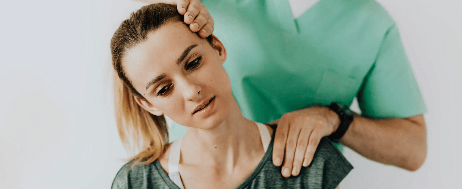 A massage therapist working on the neck of a woman.