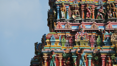 Details on the gopuram of a temple against a clear sky