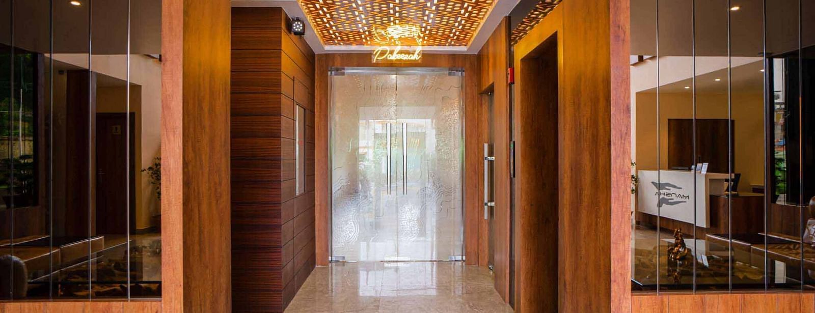 The elegantly designed entryway of Mansha Palace features wooden accents, mirrors, and warm lighting.
