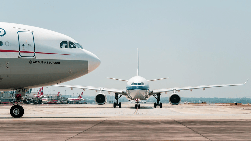 Aircraft parked on the runway, with terminal infrastructure visible in the background.