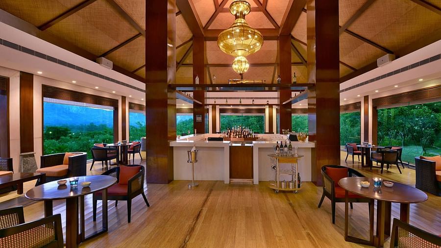 A view of float bar with tables and seating on the side and a bar counter in the centre at Float bar - The Ananta Udaipur