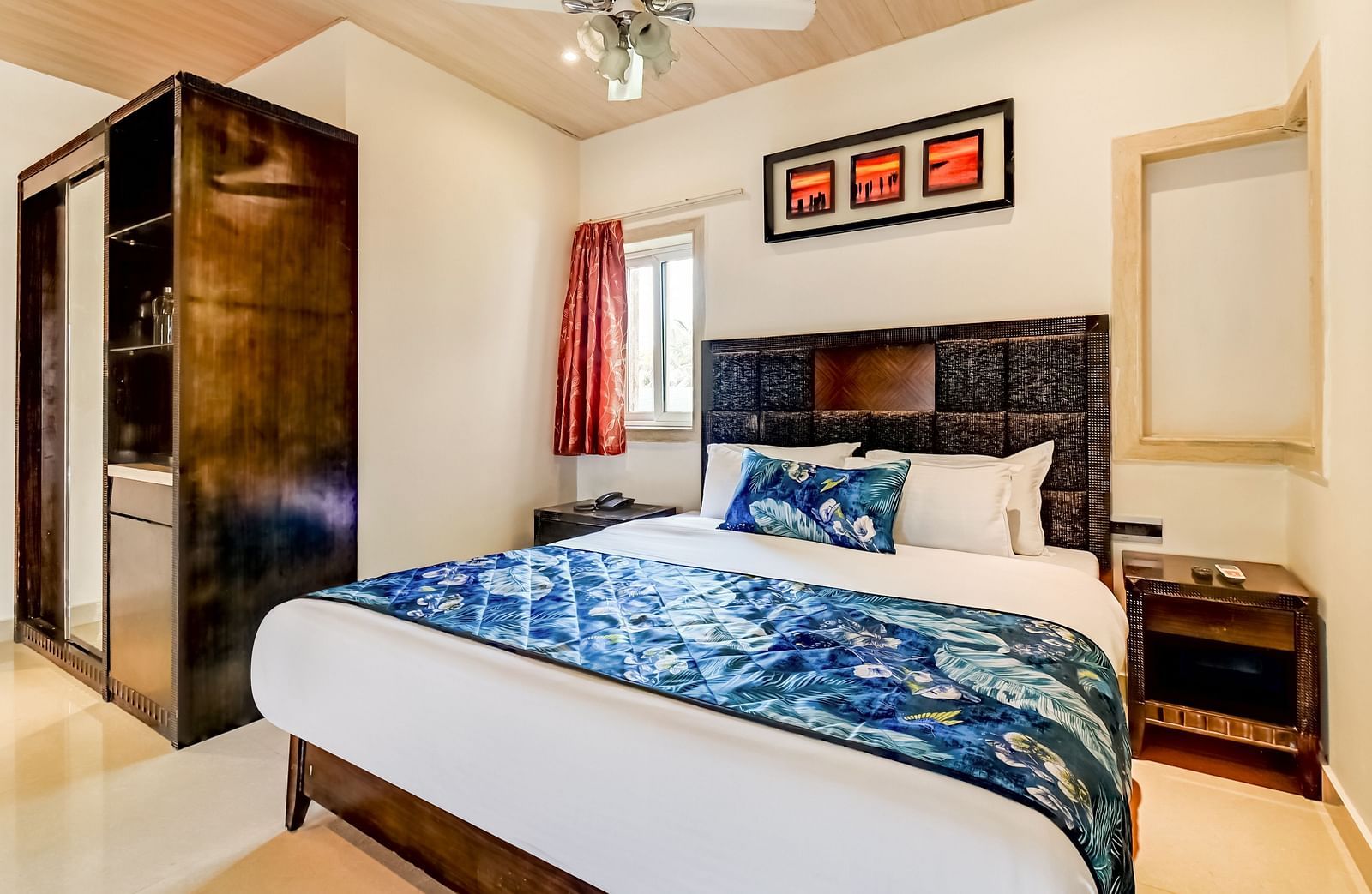  Generously sized bed accompanied by two wooden bedside tables and a large wooden wardrobe