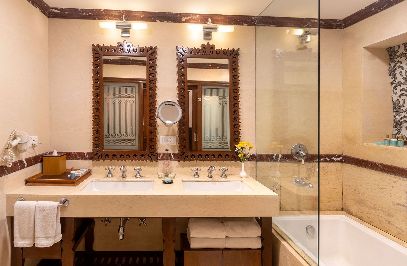 image of the bathroom with a bathtub and two separate mirrors above the sink of the Club Room at The Claridges Nabha Residence