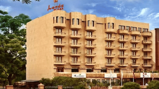 Front view of Lords Plaza Jaipur, building with balconies surrounded by beautiful trees.