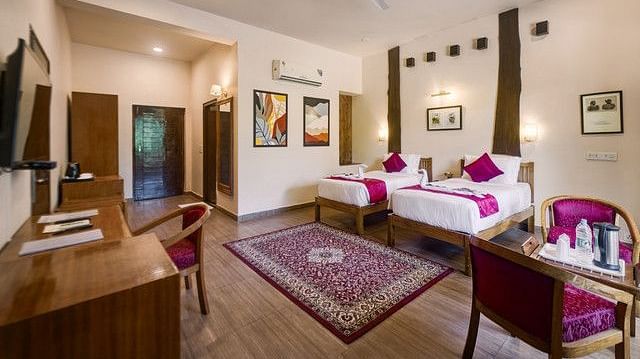 Spacious resort bedroom with a large bed, seating area, and elegant furnishings.