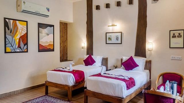 Twin beds in a well-appointed resort bedroom with artwork and decor.