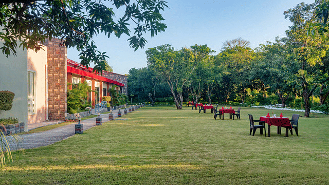 Resort grounds with green lawns, trees, and outdoor seating areas for relaxation.