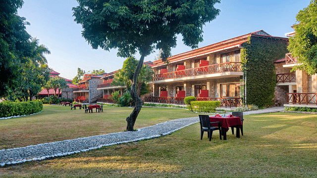 Resort exterior with surrounding trees, lawns, and outdoor seating.