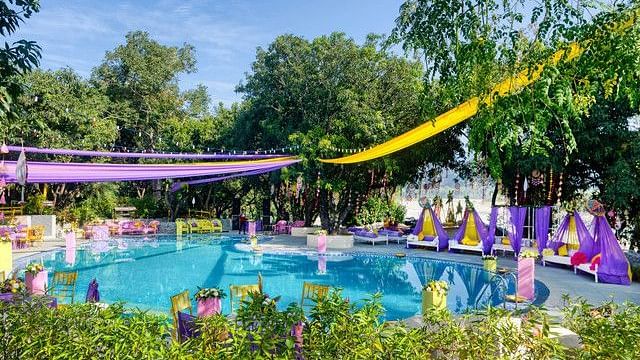 alt-text Festive poolside wedding venue with colorful decorations.