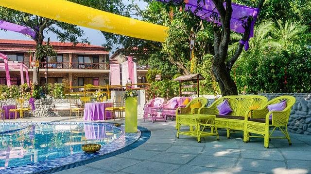 alt-text Poolside wedding venue with colorful decorations and bar area.