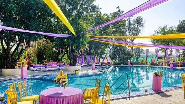 alt-text Festive poolside wedding venue with colorful decorations.