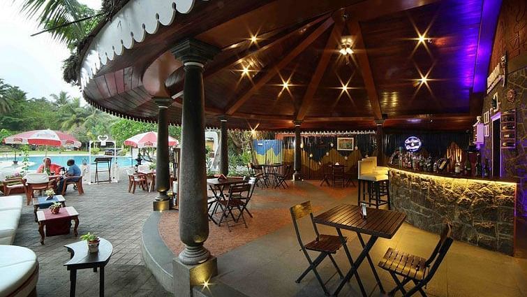 Reunion, the gastropub at Uday Samudra Leisure Beach Hotel, glows with warm and purple lighting beside the pool in the evening.